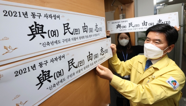 황인호 동구청장(오른쪽)이 청사 내에 사자성어 문구를 부착중이다.