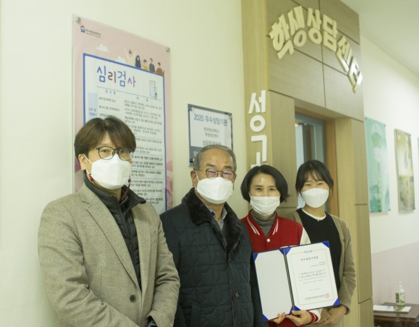 유재원 총장과 상담센터 직원들이 우수상담기관상 현판 앞에서 기념사진을 촬영하고 있다.
