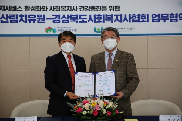 김종연(좌측) 국립산림치유원장이 18일 강창교 경상북도사회복지사협회장과 경북 예천군 효자면 국립산림치유원 산림치유문화센터에서 업무협약을 체결한 뒤 기념촬영을 하고 있다