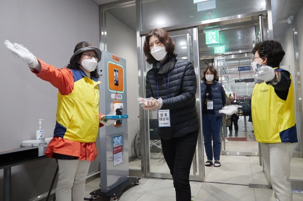 자원봉사자가 접종대상자 발열체크 및 접종 안내하는 장면