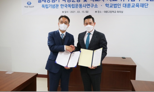 독립기념관 신주백 한국독립운동사연구소 소장(왼쪽)과 학교법인 대륜교육재단 김의용 이사장(오른쪽) 협약서 교환 장면