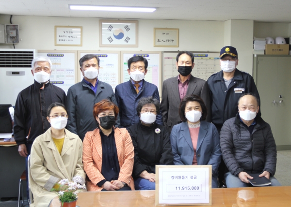 지난 6일 관리사무소에서 이 용준 경비원에게 모금액을 전달하고 기념촬영을 하고 있다.