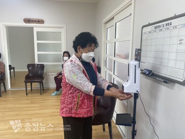 경로당 어르신이 손 소독기를 이용하는 모습