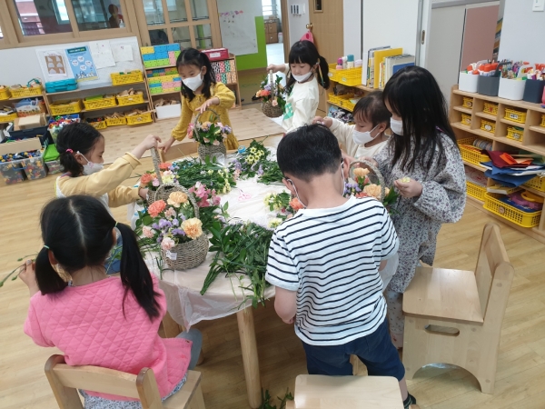 한빛유 원아들이 꽃꽂이 활동을 하고, 꽃바구니를 전달하고 있다.