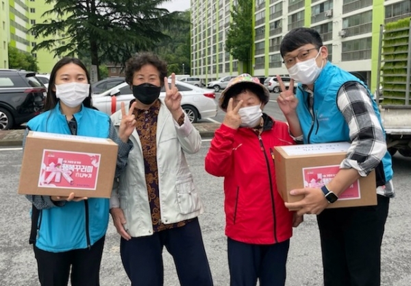 공사 직원들이 전달한 행복꾸러미를 받은 어르신들이 기념사진 포즈를 취하고 있다