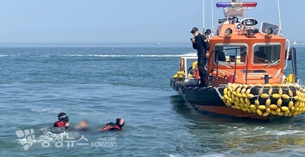 태안해경구조대가 해상서 반쯤 잠긴 채 발견된 A씨를 수습해 구조정으로 옮기고 있다. 사진=태안해양경찰서