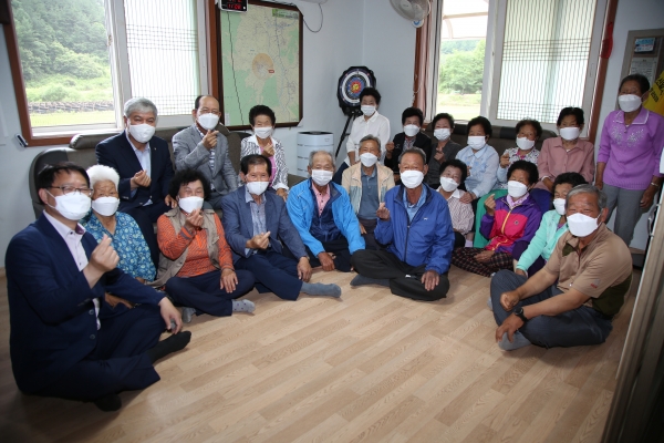 문정우 금산군수가 소파를 전달하고 주민들과 기념사진을 찍고 있다.