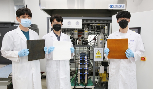 연구진이 개발한 10kW 알칼라인 수전해 스택 앞에서 스택에 사용 된 전극과 분리막을 들고 있다