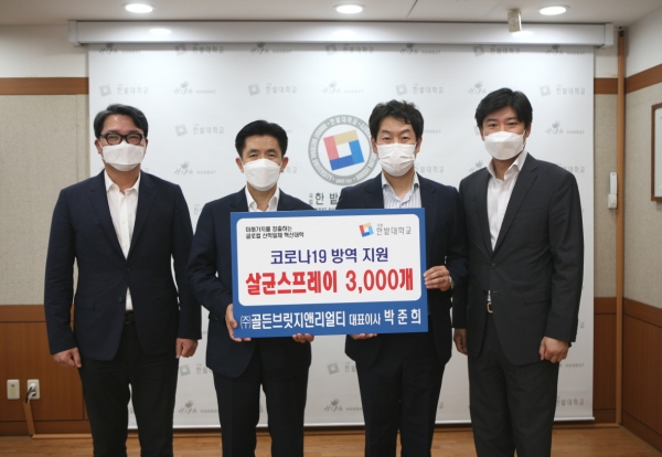 ㈜골든브릿지앤리얼티 박준희 대표(오른쪽에서 두 번째)가 모교인 한밭대학교에 코로나19 방역 지원을 위한 살균스프레이를 기증하고 최병욱 총장(왼쪽에서 두 번째) 및 관계자들과 함께 기념사진