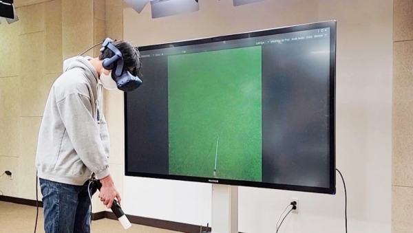 형상변이 햅틱 컨트롤러를 활용하여 골프게임을 시연하고 있는 모습