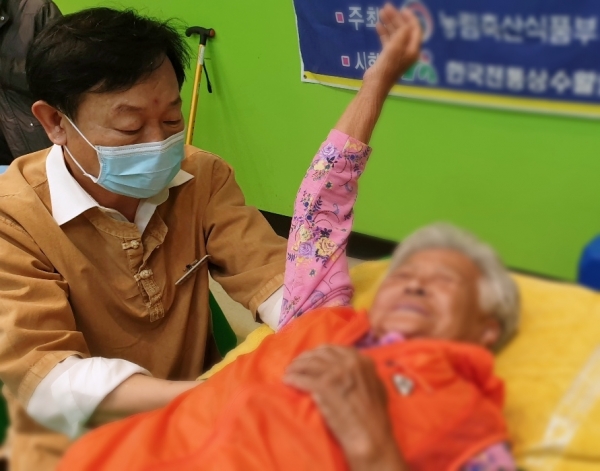 농촌재능나눔일반캠프 참석자가 근신경조정술을 통해 통증조절 치료 봉사활동을 하고 있다
