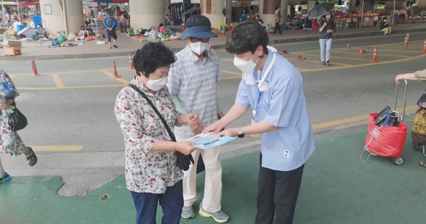 폭염질환 예방 요령이 담긴 전단지를 배부하는 장면