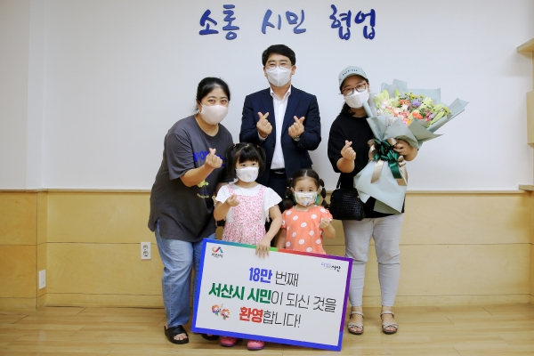 지난 12일 시장실에서 인구 18만 돌파를 기념해 18만 번째 서산시민이 된 염모 씨(41ㆍ여) 가족을 초청해 꽃다발을 증정하고 기념하는 모습