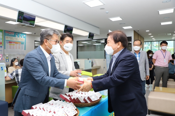 길정섭 충남세종농협본부장(왼쪽)과 이기범 농협노조 충남세종지역위원장(왼쪽 두 번째)이 농협 창립60주년을 기념하는 축하떡을 고객들에게 나누어주고 있다.