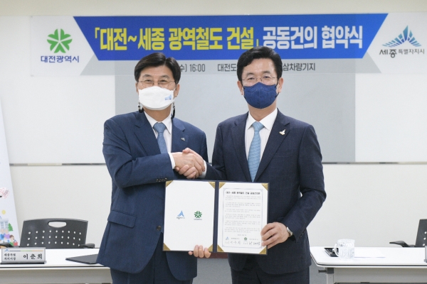 이춘희 세종시장(좌)과 허태정 대전시장(우)이 7일 대전-세종 광역철도 건설 공동건의문에 서명 후 악수하고 있다.