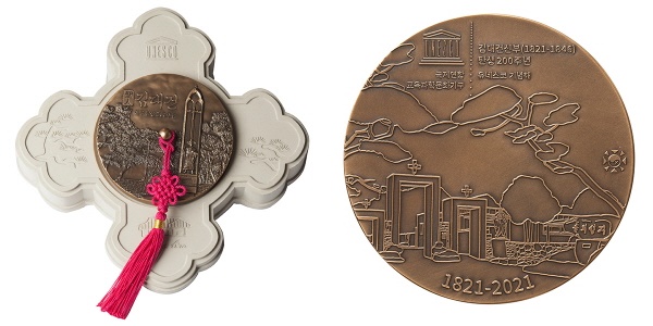 성 김대건 신부의 동상과 탄생지인 솔뫼성지 소나무 군락지(앞면), 김대건 신부를 비롯해 4대에 걸친 순교자가 살았던 솔뫼성지(뒷면)를 표현했다