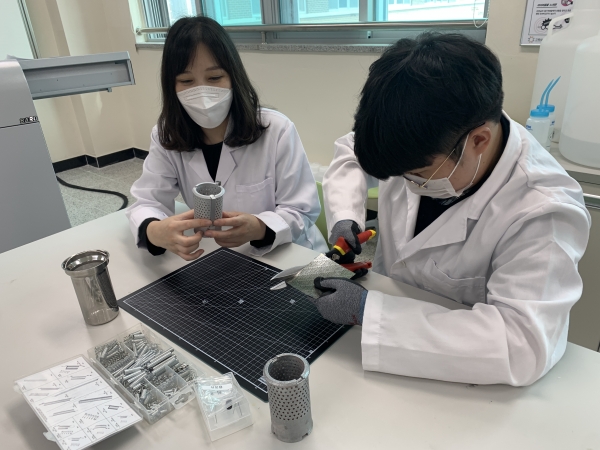 장정희 지도교사가 송민준 학생과 실험을 하고 있다.