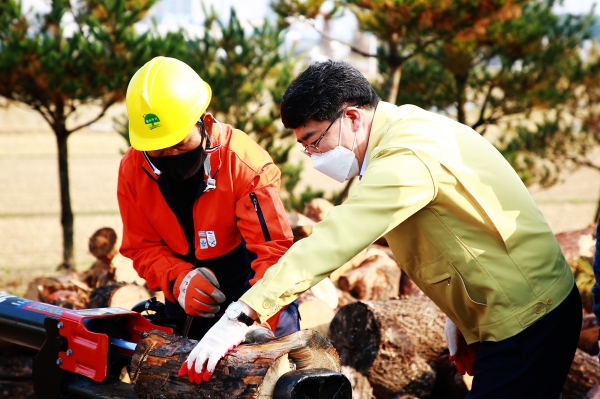 맹정호 서산시장이 4일 서산시임업기계창고에서 나눔할 땔감을 알맞은 크기로 자르는 모습