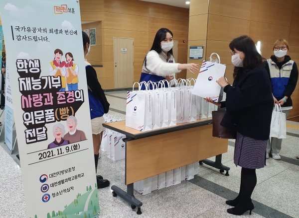 보훈음악회에 참석한 분들께 청소년적십자 RCY 학생들이 빵을 나눠주고 있는 모습