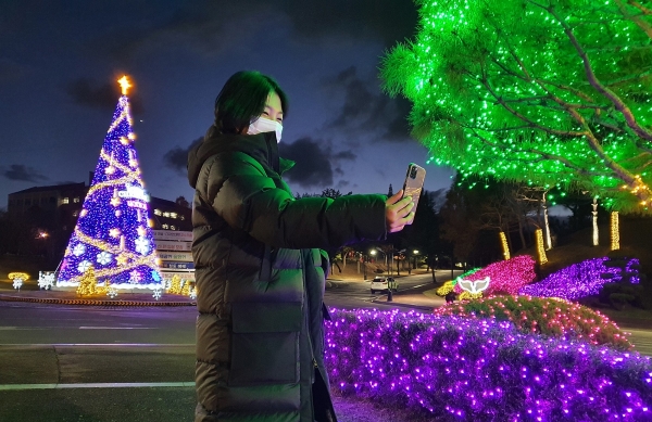 9일 오후 목원대학교 학생회관 앞 회전교차로에 설치된 크리스마스트리에서 한 시민이 기념촬영
