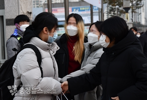 18일 수능을 보러 온 수험생의 부모와 친구들이 손을 잡고 격려하고 있다. / 충청뉴스 이성현 기자