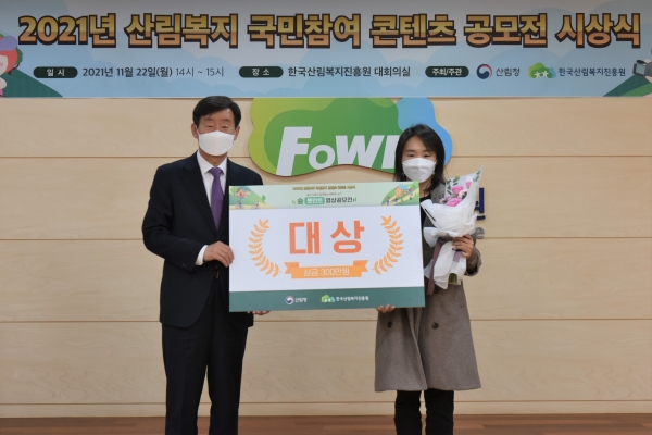 이창재(좌측) 한국산림복지진흥원장이 22일 대전 서구 둔산북로 한국산림복지진흥원 대회의실에서 ‘2021년 산림복지 국민참여 콘텐츠 공모전’ 영상부문 대상 수상자(배유미 님)와 기념촬영