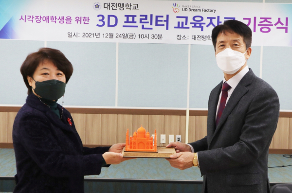 국립한국복지대학교 메이커 교육센터 임진이 센터장이 대전맹학교 박준상 교장에게 타지마할 모형을 전달하는 모습