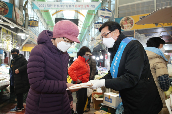 오봉록 수도부문이사(사진 오른쪽)가 친환경 업사이클링 제품으로 제작한 홍보용 에코백을 시민에게 전달하고 있다.