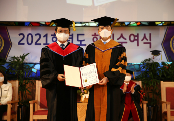 17일 오전 목원대 채플에서 열린 2021학년도 학위수여식에서 이웅천 둔산성광교회 담임목사(왼쪽)가 권혁대 총장으로부터 학위기를 받고 있다.