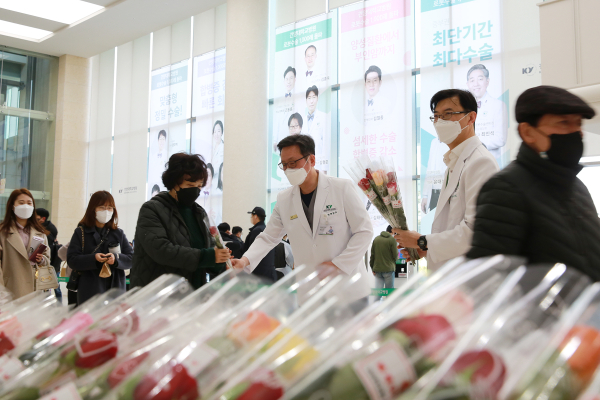 배장호 의료원장이 내원객들에게 꽃을 선물하는 모습
