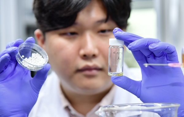 KIST 정영균 박사후 연구원이 개발한 금 회수 소재를 통해 추출된 금을 살펴 보고 있다.