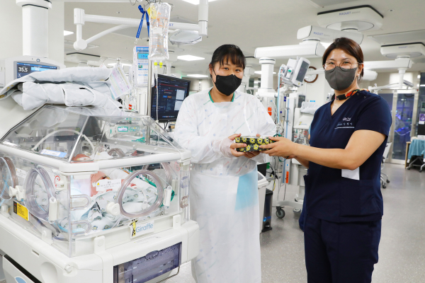 신생아중환자실에서 치료 중인 아기 환아의 엄마에게 소아청소년과 신정민 교수가 어린이날 선물을 전달하고 있다.