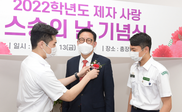 문용제 학군 후보생(스마트자동차학과 4학년)이 김승우 총장에게 감사와 존경의 카네이션을 달아드리고 있다.