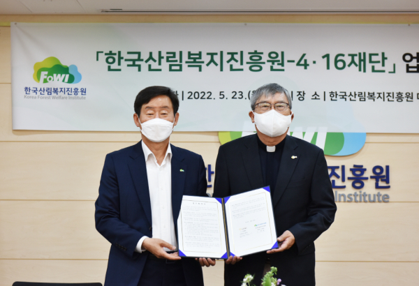 이창재(좌측) 한국산림복지진흥원장이 23일 한국산림복지진흥원(대전 서구 둔산북로) 대회의실에서 김광준 4·16재단 이사장과 업무협약서를 들고 기념촬영