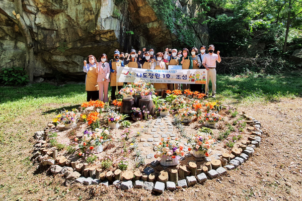 오은정 부춘동장이 26일 주민들과 나도정원 1호 앞에서 기념촬영하는 모습