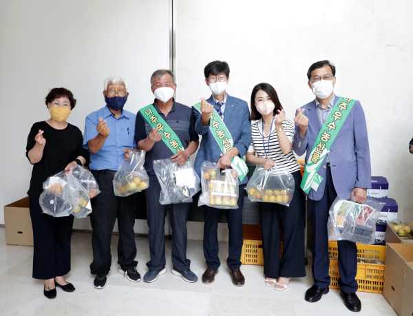 22일 본사 1층에서 진행한 지역 농가 돕기 농산물 사주기 캠페인에서 직원들이 구매 농산물을 들고 포즈를 취하고 있다.(사진 오른쪽에서 세 번째- 송성일 농어촌개발이사)