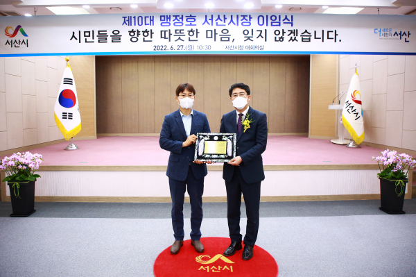 맹정호 서산시장이 27일 시청 대회의실에서 열린 이임식에서 재직기념패를 받는 모습(좌부터 구상 부시장, 맹정호 서산시장)