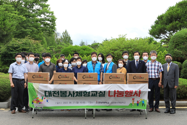 봉사체험교실 유대영 부회장(사진 오른쪽)이 한남대 용역직원 대표(왼쪽)와 봉사단 학생(가운데)에게 물품 전달