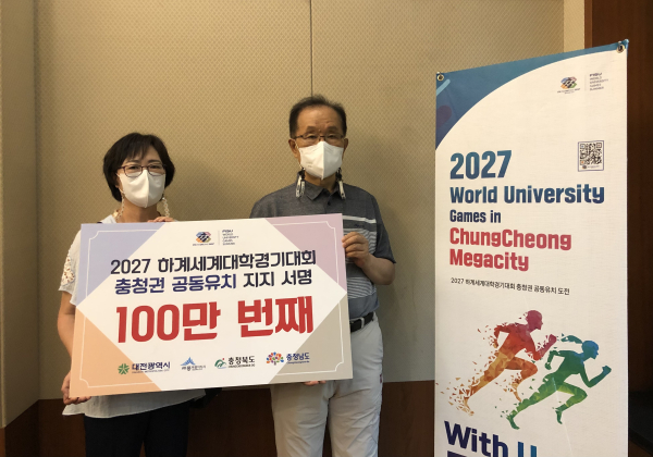 충청권 공동유치위원회 김윤석 사무총장(오른쪽)이 100만번째 서명 참여자와 함께 기념촬영을 하고 있다.