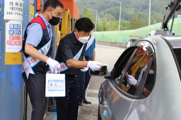 한국도로공사 대전영업소 에서 한국도로공사 대전충남본부장 박현섭(오른쪽), 대전충남노조 조종성 위원장(왼쪽)이 교통안전캠페인을 진행하면서 고객에게 (통행권과) 얼음생수, 비상LED, 안전쿠키 등이 포함된 안전키트를 배부하고 있다.