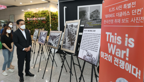 박희조 동구청장이 동구청 1층 로비에서 6‧25전쟁 특별 사진전을 관람하고 있다.