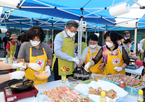 7일 유성구 지역협력센터에 정용래 유성구청장(가운데)이 자원봉사자들과 함께 삼색전을 부치고 있