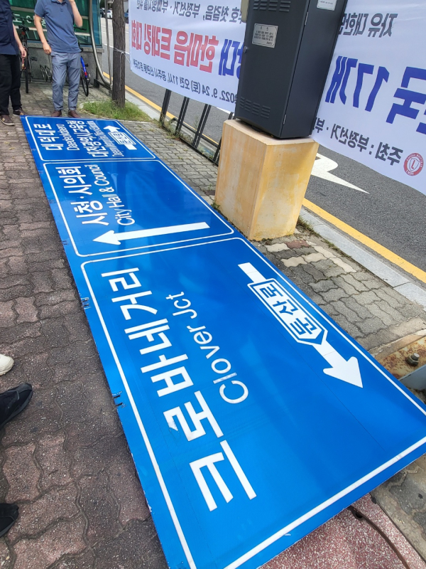 19일 대전시 서구 둔산동 시청역네거리에 설치된 도로표지판이 떨어지면서 소방당국과 행정당국이 인도로 옮겨 놓은 모습.