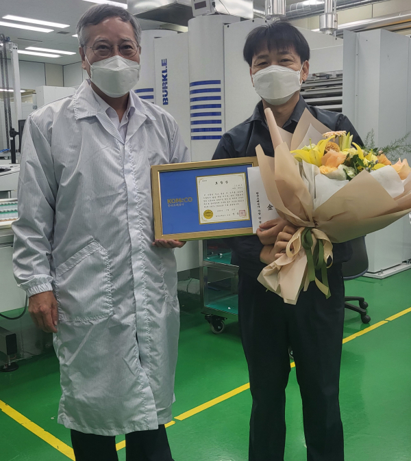 반장식 사장이 품질 명장 정병진 차장에게 CEO΄s Choice 포상한 뒤 기념사진을 찍고 있다