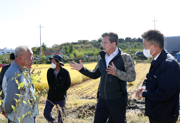 18일 벼 베기 행사가 열린 가운데, 참석한 정용래 유성구청장(가운데)이 농민들을 격려하고 있다.