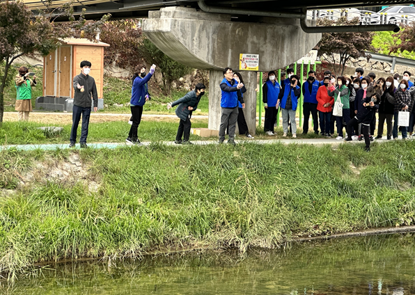강원본부 봉사단이 24일 원주천 정화 활동을 위해 직접 만든 EM 흙공을 던지고 있다.