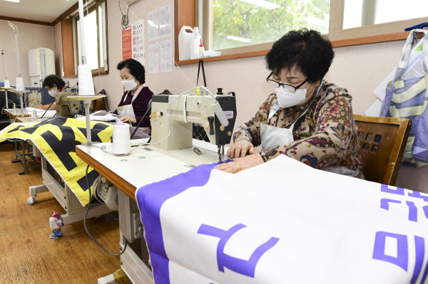 중구시니어클럽에서 폐현수막 마대를 제작 중인 어르신 모습