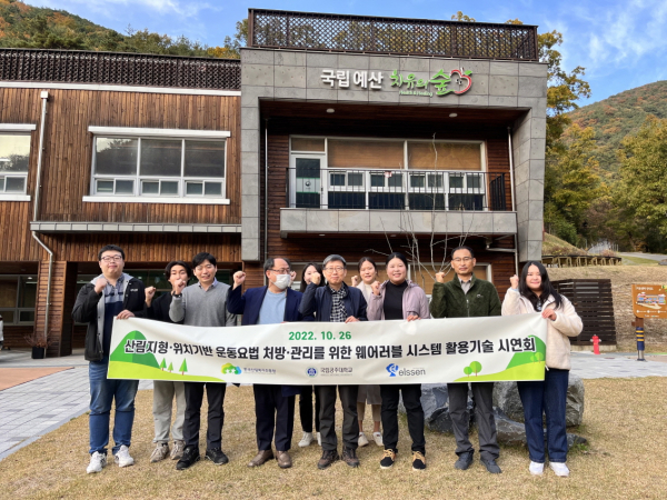 산림헬스케어 웨어러블 시스템 활용기술 시연회 참가자들이 지난 26일 충남 예산군 국립예산치유의숲에서 행사에 앞서 현수막을 들고 사진을 찍고 있다.