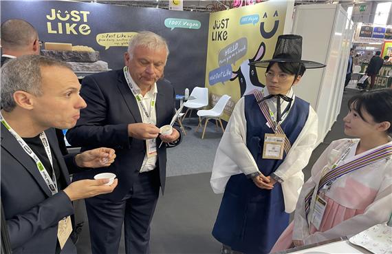 금산인삼 요거트(시연시식)를 맛보는 해외 참관객과 한복을 입고 참관객을 맞이하는 금산인삼홍보관 현장 스텝