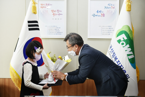 남태헌 원장이 지난 1일 한국산림복지진흥원(대전 서구 둔산동)에서 제5회 산림복지 어린이 그림 공모전 수상자에게 꽃과 상장을 건네고 있다.